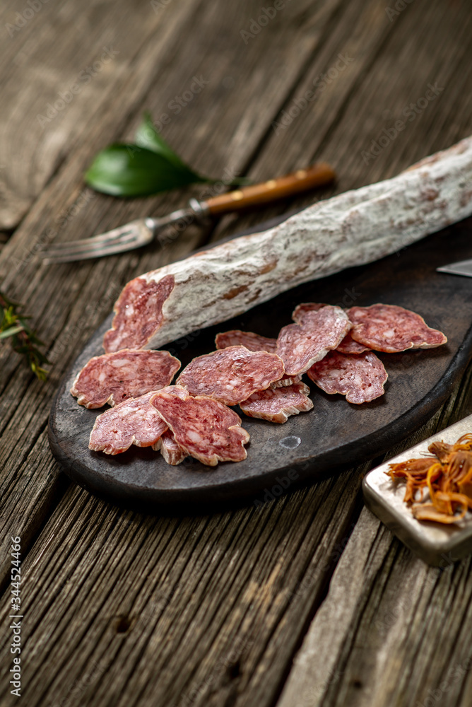 Dried sausage on wooden board with spices chili pepper wooden texture cuisine Dried sausage on wooden board with spices chili pepper wooden texture cuisine