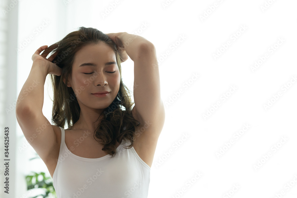 Asian woman cheerful and healthy and wearing white pajamas wake up on bed in bedroom in the morning.at home in holiday. Asian woman cheerful and healthy and wearing white pajamas wake up on bed in bedroom in the morning.at home in holiday.