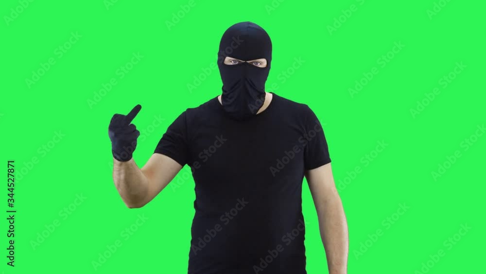 Man in balaclava shows middle finger.,green screen background Man in balaclava shows middle finger.,green screen background