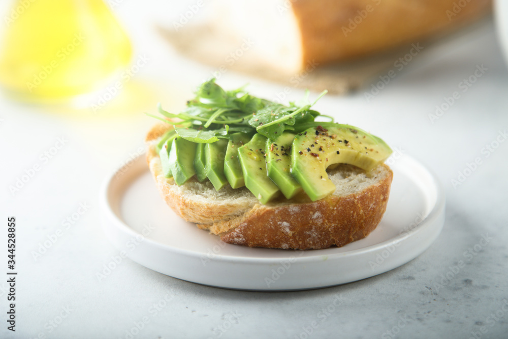 Homemade healthy avocado toast with fresh arugula