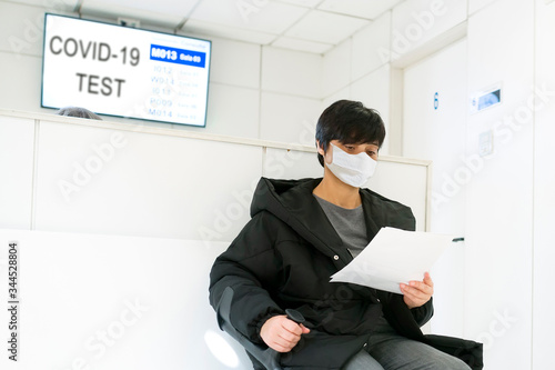woman in hospital waiting room for coronavirus covid-19 test