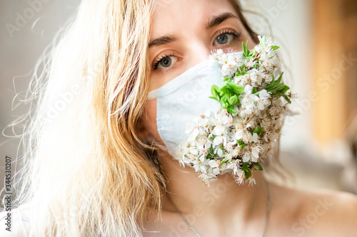 
girl in white medical mask and spring blossom