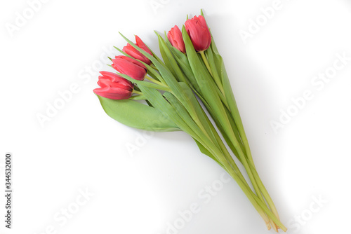 Bouquet of five red tulips on a white background with leaves  isolated  top view