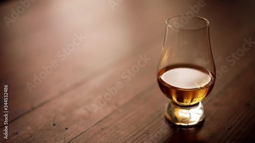 HD high angle tracking shot footage of a Glencairn whisky glass, with shallow depth of field.