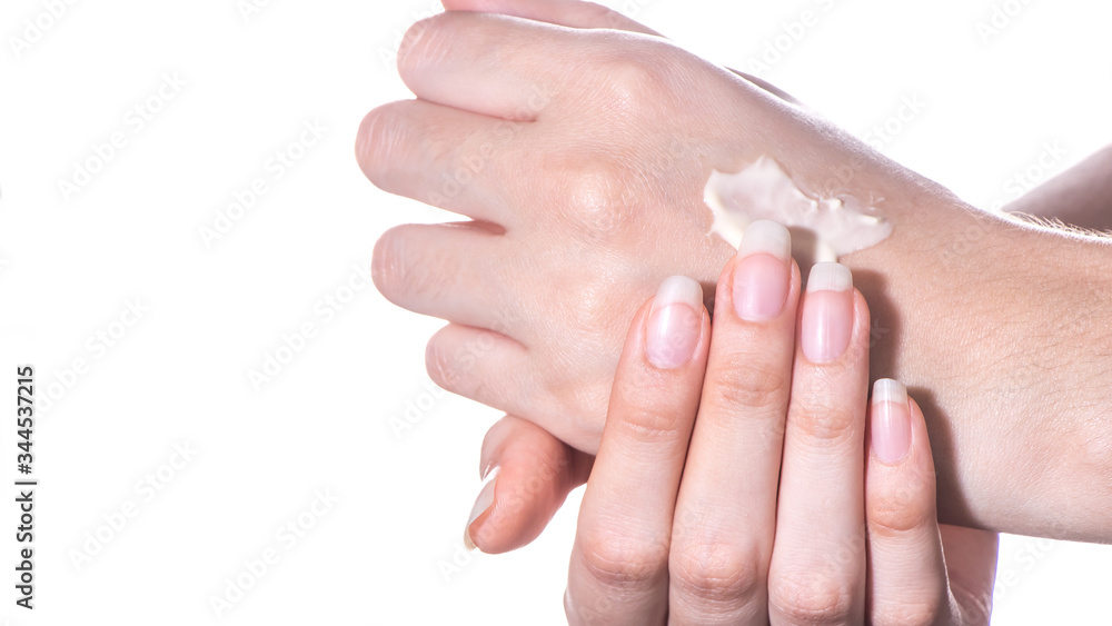 The girl applies a moisturizer or lotion to the skin of the hand on a white background isolated close-up.Spa,skin care at home or in a beauty salon.Treatment and hydration of the skin and cosmetology The girl applies a moisturizer or lotion to the skin of the hand on a white background isolated close-up.Spa,skin care at home or in a beauty salon.Treatment and hydration of the skin and cosmetology