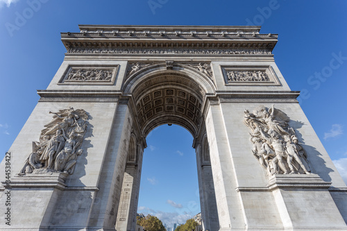 Looking up at the Arc de Triomphe in Paris France with clear blue sky