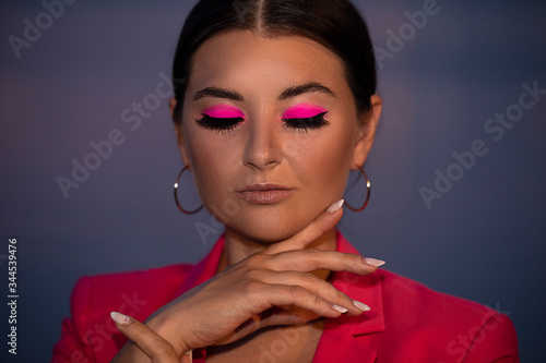beautiful girl with bright pink make-up on a background of the sea