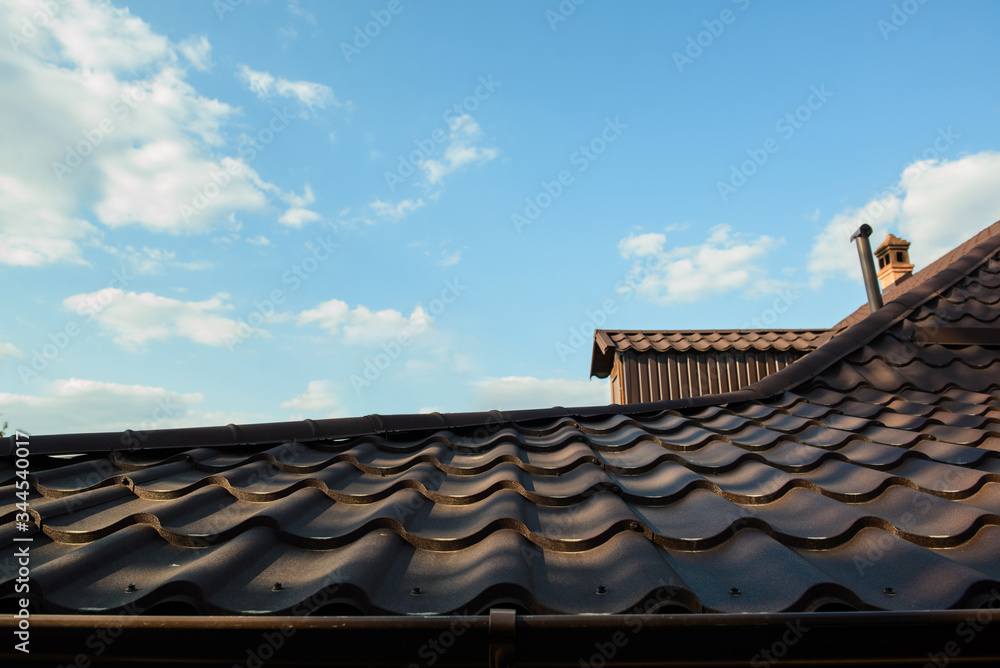 roof of a house on a blue sky with clouds.