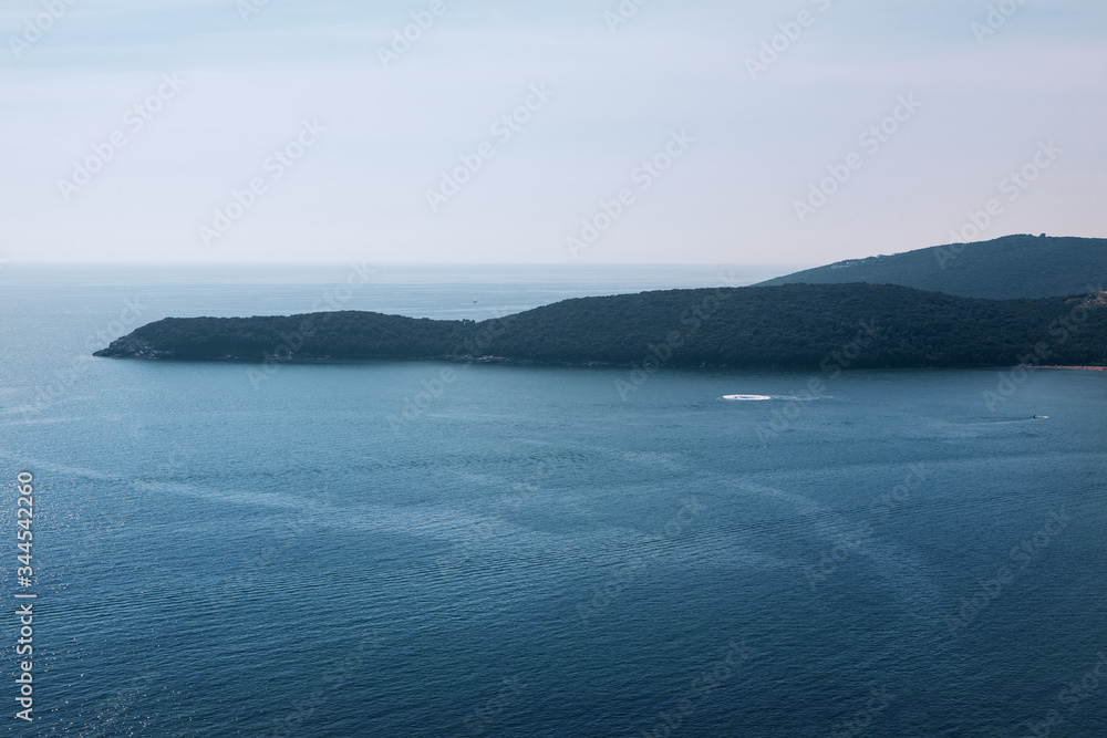 peninsula in the blue sea , morning scenery of coastal mountains