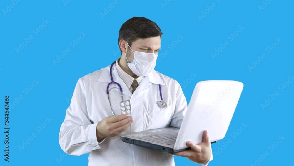 The doctor holds in his hand a tablet communicates via video link on a laptop. The doctor holds in his hand a tablet communicates via video link on a laptop.