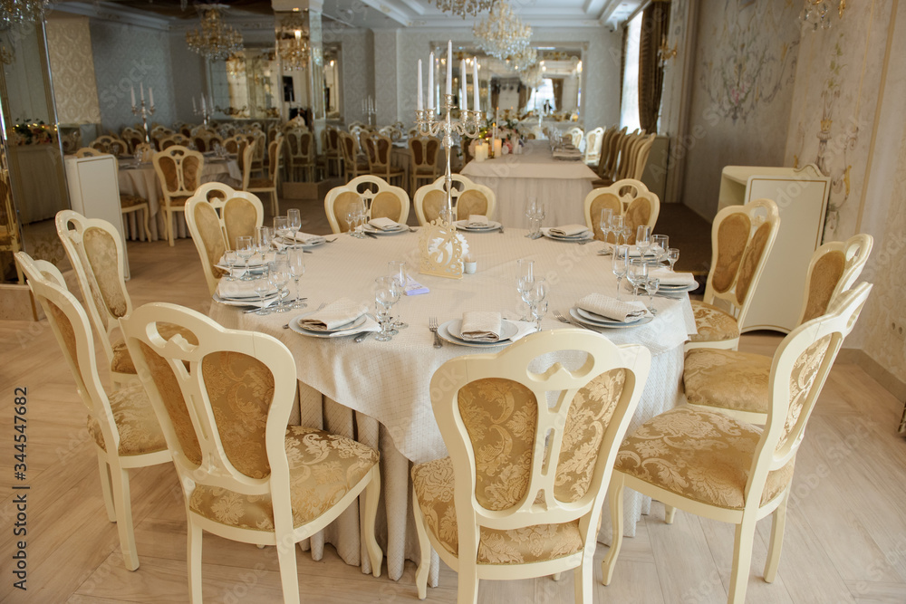 White table with plates knives, forks and napkins. White table with plates knives, forks and napkins.