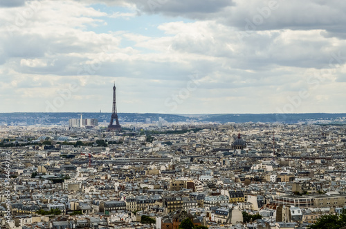 Paris skyline, view from the Sacre Coeur on Montmartre hill, France. Basilica of Sacre Coeur is one of the landmarks in Paris. Aerial view of Paris in summer. Panorama of Paris city on a cloudy day. © sebastianosecondi