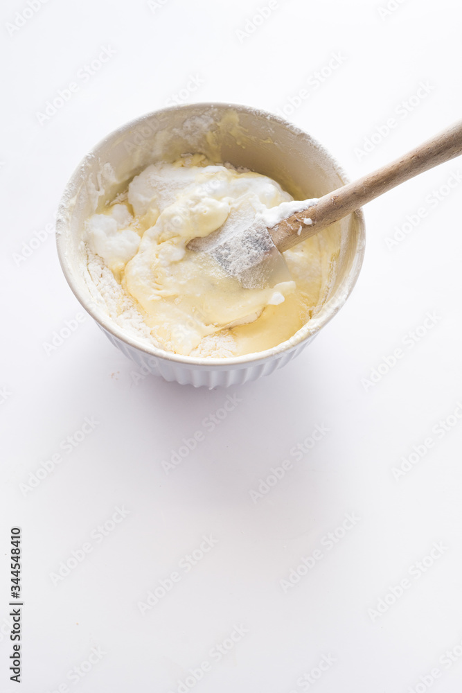 Preparation of savoiardi biscuits , step by steps visual recipe, whipped eggs white are mixed with eggs yolk gently with a spatula Preparation of savoiardi biscuits , step by steps visual recipe, whipped eggs white are mixed with eggs yolk gently with a spatula