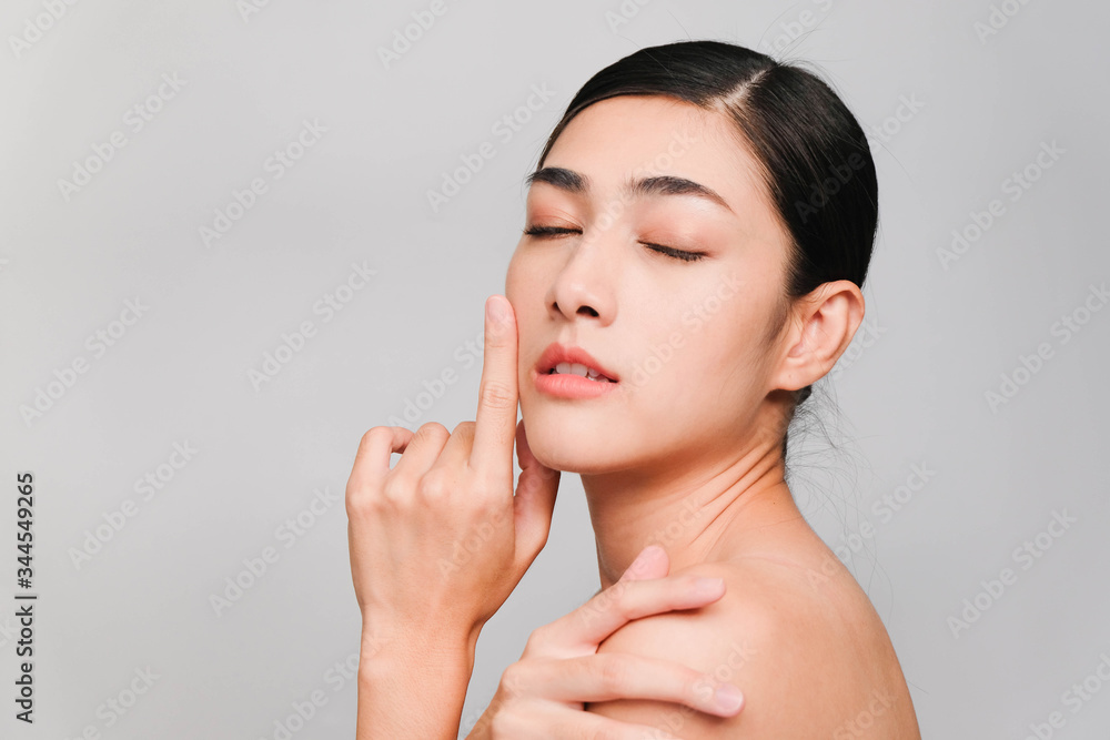 Beautiful asian woman ,young asian girl with clean and bright skin, Cosmetic Beauty Concept,hands touch on the cheek,smily and friendly face isolated on grey background Beautiful asian woman ,young asian girl with clean and bright skin, Cosmetic Beauty Concept,hands touch on the cheek,smily and friendly face isolated on grey background