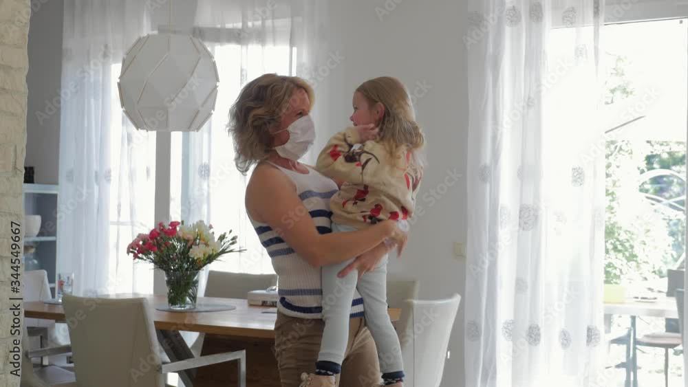 Woman with Face Mask Playing with Child in Living Room Woman with Face Mask Playing with Child in Living Room
