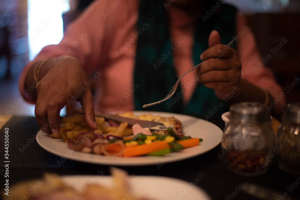 Blurred half face portrait of an Indian woman eating ice cream and brownie with a spoon inside a cafe or ice cream parlor. Indian lifestyle Blurred half face portrait of an Indian woman eating ice cream and brownie with a spoon inside a cafe or ice cream parlor. Indian lifestyle