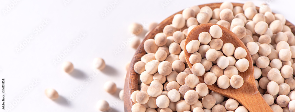 Dry raw brown tapioca pearls in a wooden bowl with spoon isolated on white background, close up, ingredient of making bubble boba milk tea. Dry raw brown tapioca pearls in a wooden bowl with spoon isolated on white background, close up, ingredient of making bubble boba milk tea.