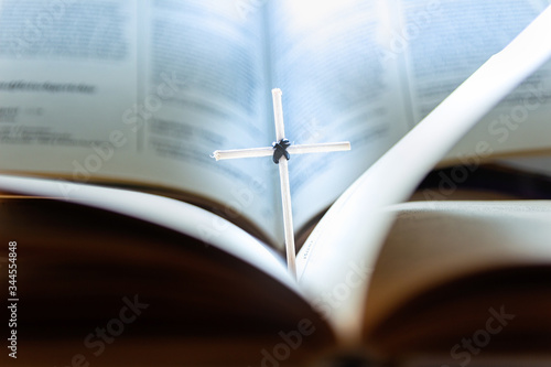 Open Holy Bible book and homemade cross, close-up view © EUDPic