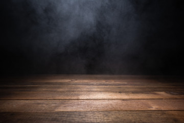 empty wooden table with smoke float up on dark background
