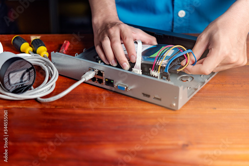 Technician remove a hard disk drive from the CCTV DVR recorder case , to install a new hard drive and upgrading to a Solid State Drive (SSD) in to surveillance DVR.