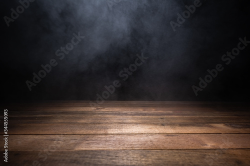 Fotografia empty wooden table with smoke float up on dark background