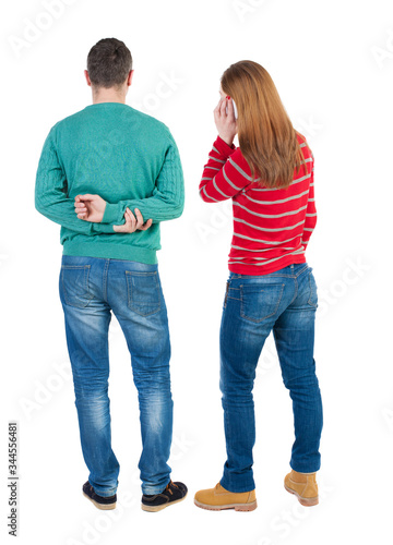 Back view of couple in sweater with mobile phone.