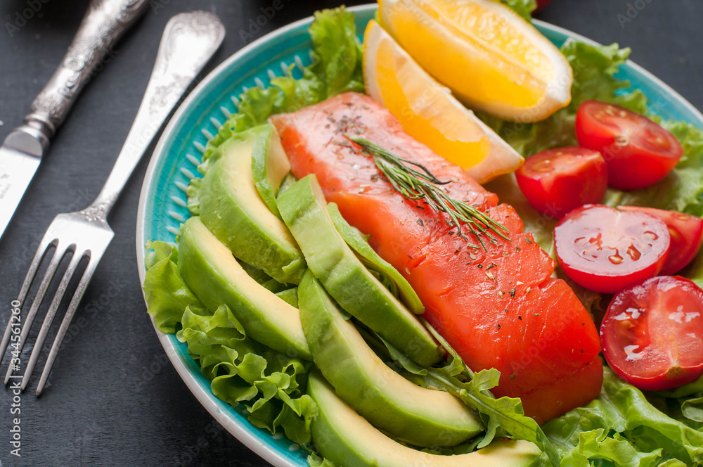 Salted salmon on lettuce with sliced avocado, herbs and spices Salted salmon on lettuce with sliced avocado, herbs and spices