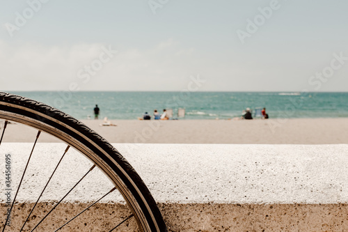 A wheel of a bicycle parked on a beach