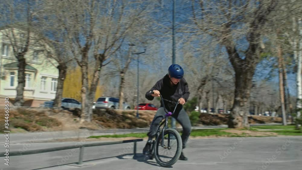 A young bmx rider jumps with rotating across pipe at skate park. A young bmx rider jumps with rotating across pipe at skate park.