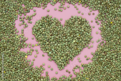 Lentils in the form of a heart on a pink background