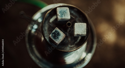 Shisha hookah with red hot coals. Sparks from breathe. Toned image. Modern hookah with coconut charcoal for relax and shisha smoke. Hookah and sparks from coals. from the top close up view
