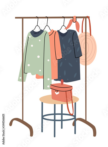 Rail with a summer wardrobe. Bright dresses, a hat and a straw bag. Shopping. Decor in the room. Summer mood. Spring fashion - pastel colored clothes on rail. Sale at clothing store concept.