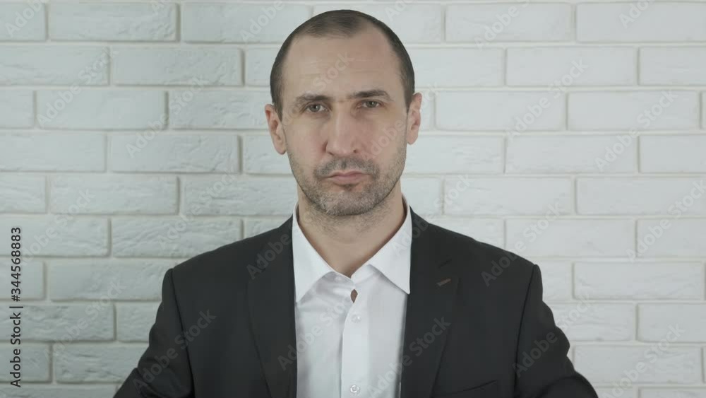 A man in a business suit puts on a protective mask