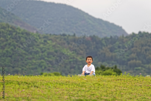 A little boy sitting on the grass © zirong