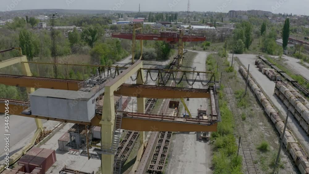 Aerial view of railroad by overhead cranes. The mobile crane loads the truck. Aerial view of railroad by overhead cranes. The mobile crane loads the truck.
