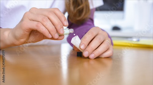 female doctor prepares homeopathic medicine - globules photo