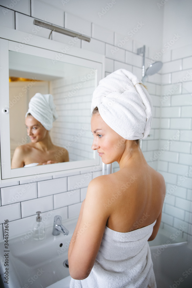 Close up of beautiful young woman examining herself in front of mirror. Close up of beautiful young woman examining herself in front of mirror.
