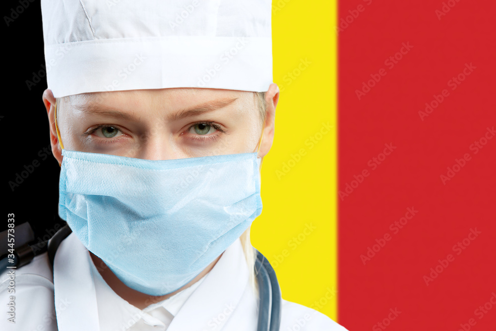 Female young doctor with stethoscope and face mask praying for God with Germany national flag on background. Concept of healthcare and medicine, coronavirus pandemic, danger epidemic, COVID. Female young doctor with stethoscope and face mask praying for God with Germany national flag on background. Concept of healthcare and medicine, coronavirus pandemic, danger epidemic, COVID.