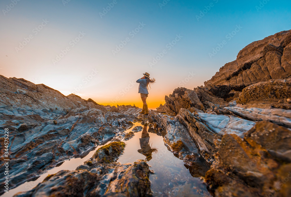 Obraz premium Lifestyle, a young businesswoman on the rocks by the sea
