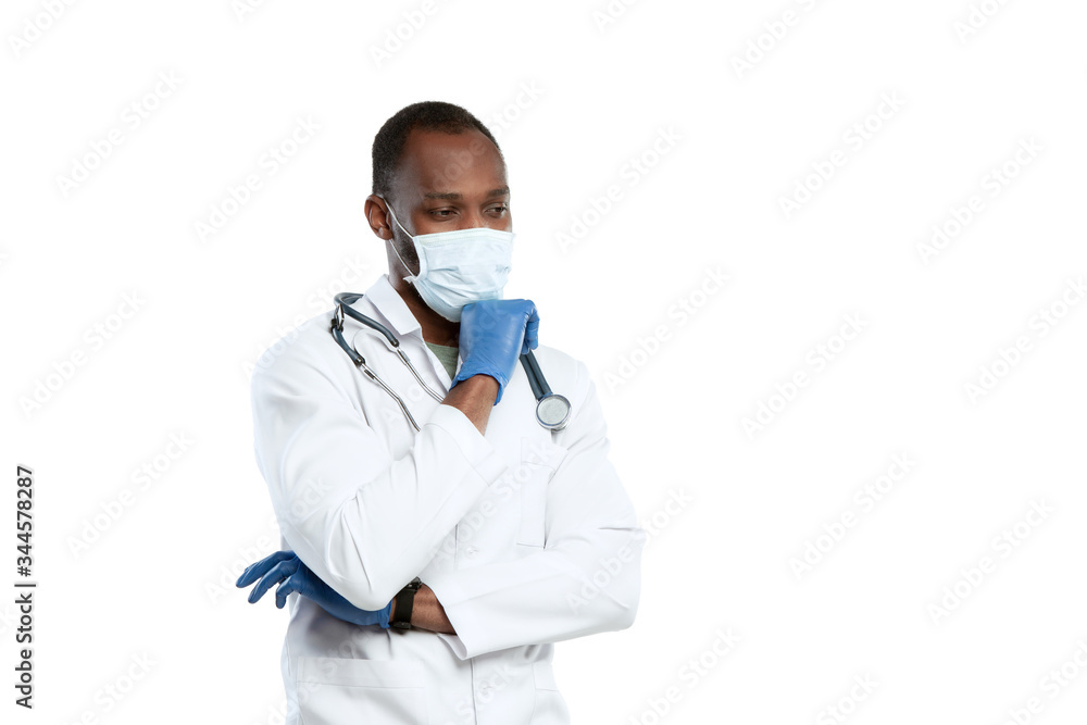 Despair, depressed. Male young doctor with stethoscope and face mask on white studio background. Looks sad, serious. Concept of healthcare and medicine, coronavirus pandemic, danger epidemic, COVID. Despair, depressed. Male young doctor with stethoscope and face mask on white studio background. Looks sad, serious. Concept of healthcare and medicine, coronavirus pandemic, danger epidemic, COVID.