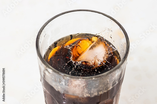 whiskey cocktail with cola and ice in a transparent glass with beautiful splashes