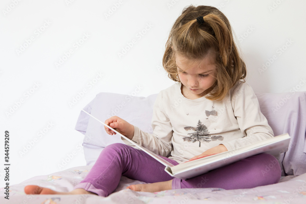 Girl child sit bed read book Girl child sit bed read book