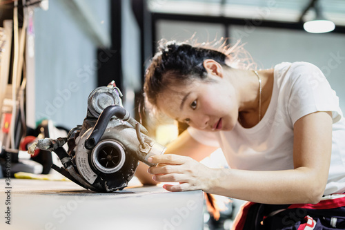 Billede på lærred Mechanic woman try to fix used turbocharger in the garage