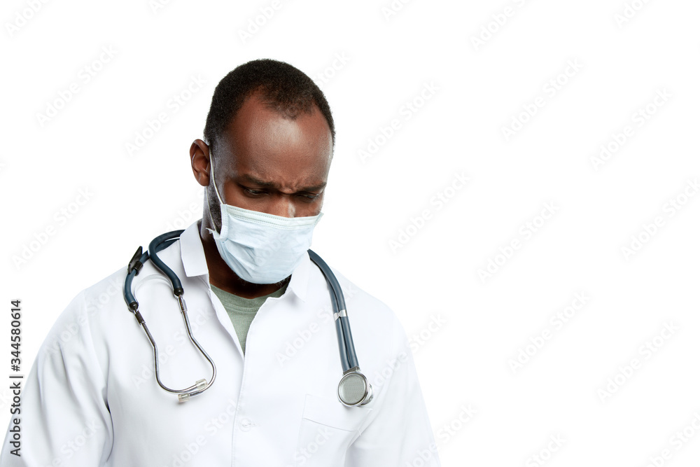 Despair, depressed. Male young doctor with stethoscope and face mask on white studio background. Looks sad, serious. Concept of healthcare and medicine, coronavirus pandemic, danger epidemic, COVID. Despair, depressed. Male young doctor with stethoscope and face mask on white studio background. Looks sad, serious. Concept of healthcare and medicine, coronavirus pandemic, danger epidemic, COVID.