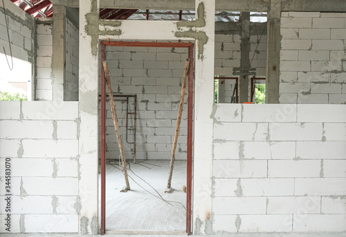 lightweight cement brick and white lintel plaster to joint for reinforce door in house construction site.