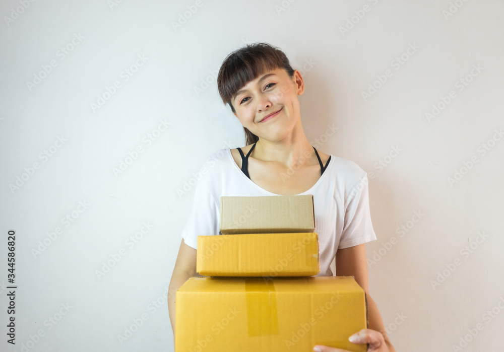 Asian woman smiling carrying three cardboard boxes. Startup small business concept