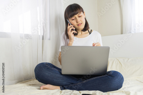 Asian woman using smartphone at home. Social distancing concept. Work from home concept, work remotely concept