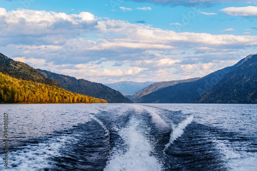 Fotografi The wake of the stern of a motor boat sailing on a mountain lake
