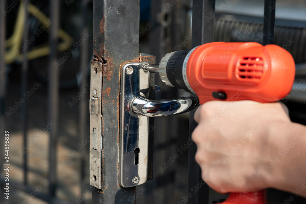 The hand is drilling the hole Repair damaged doors The hand is drilling the hole Repair damaged doors