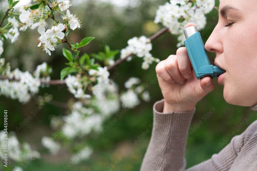 Blond woman with respiratory disease diagnosed with asthma uses an inhaler Blond woman with respiratory disease diagnosed with asthma uses an inhaler